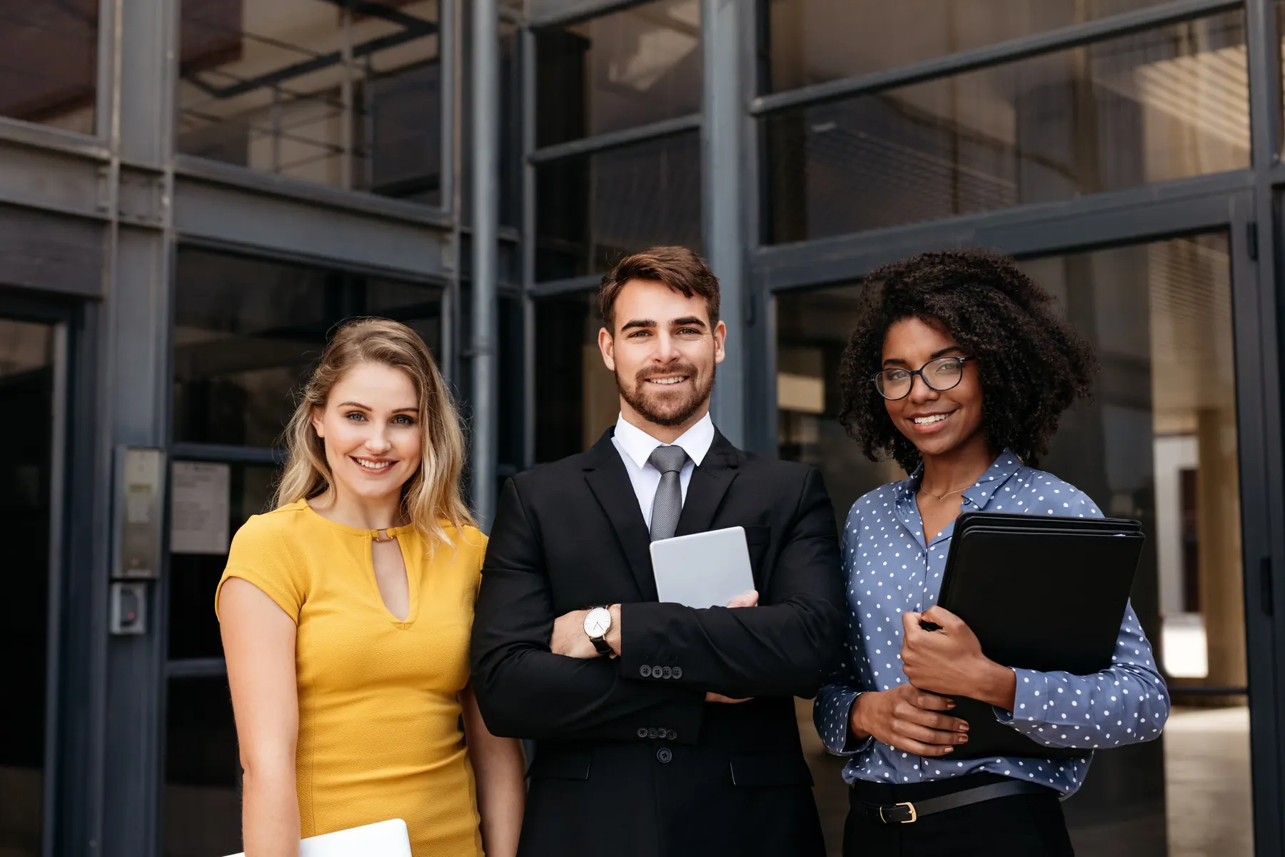 Three EMG Attorneys professionals standing outside an office building