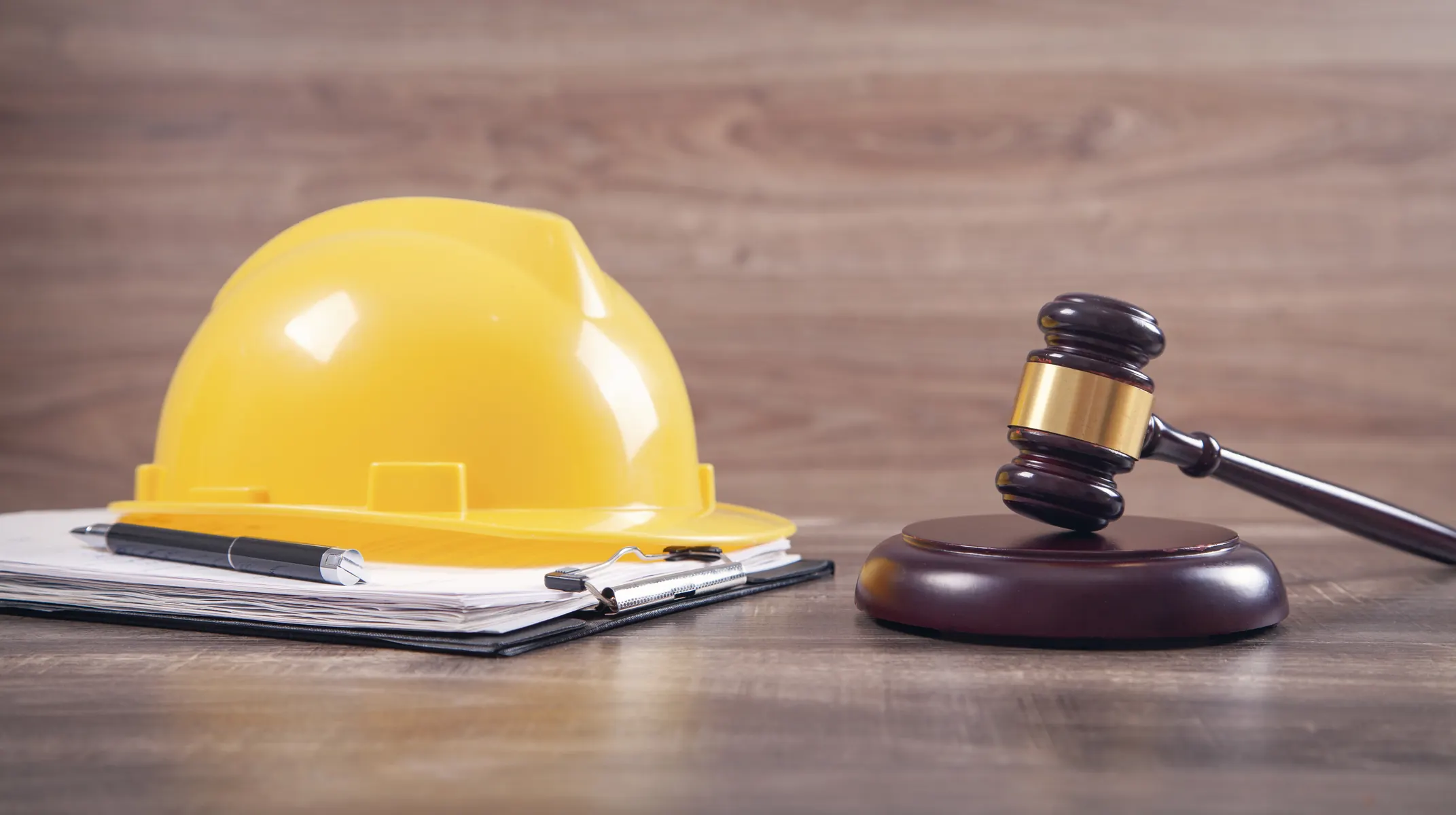Yellow hard hat and gavel on construction plans