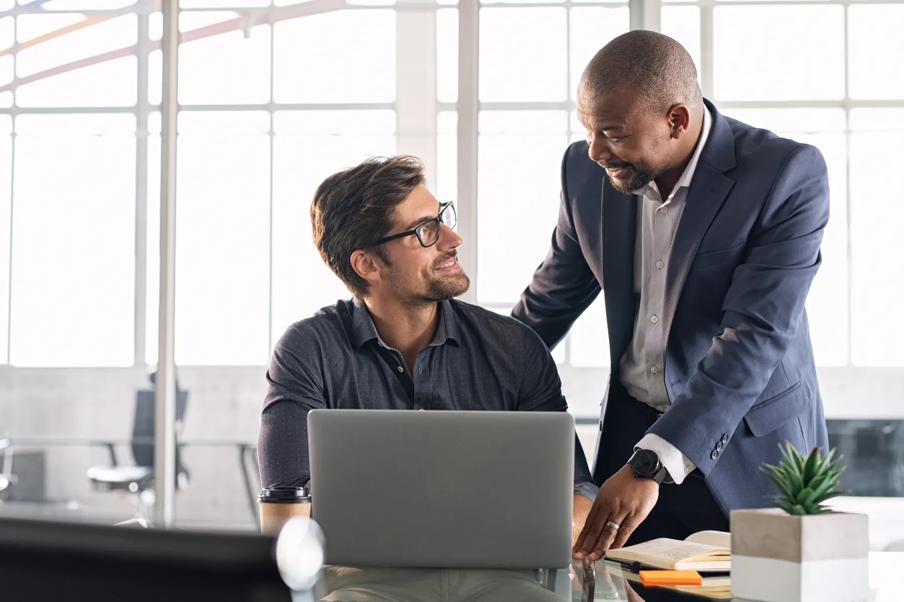 Two colleagues in discussion at a laptop